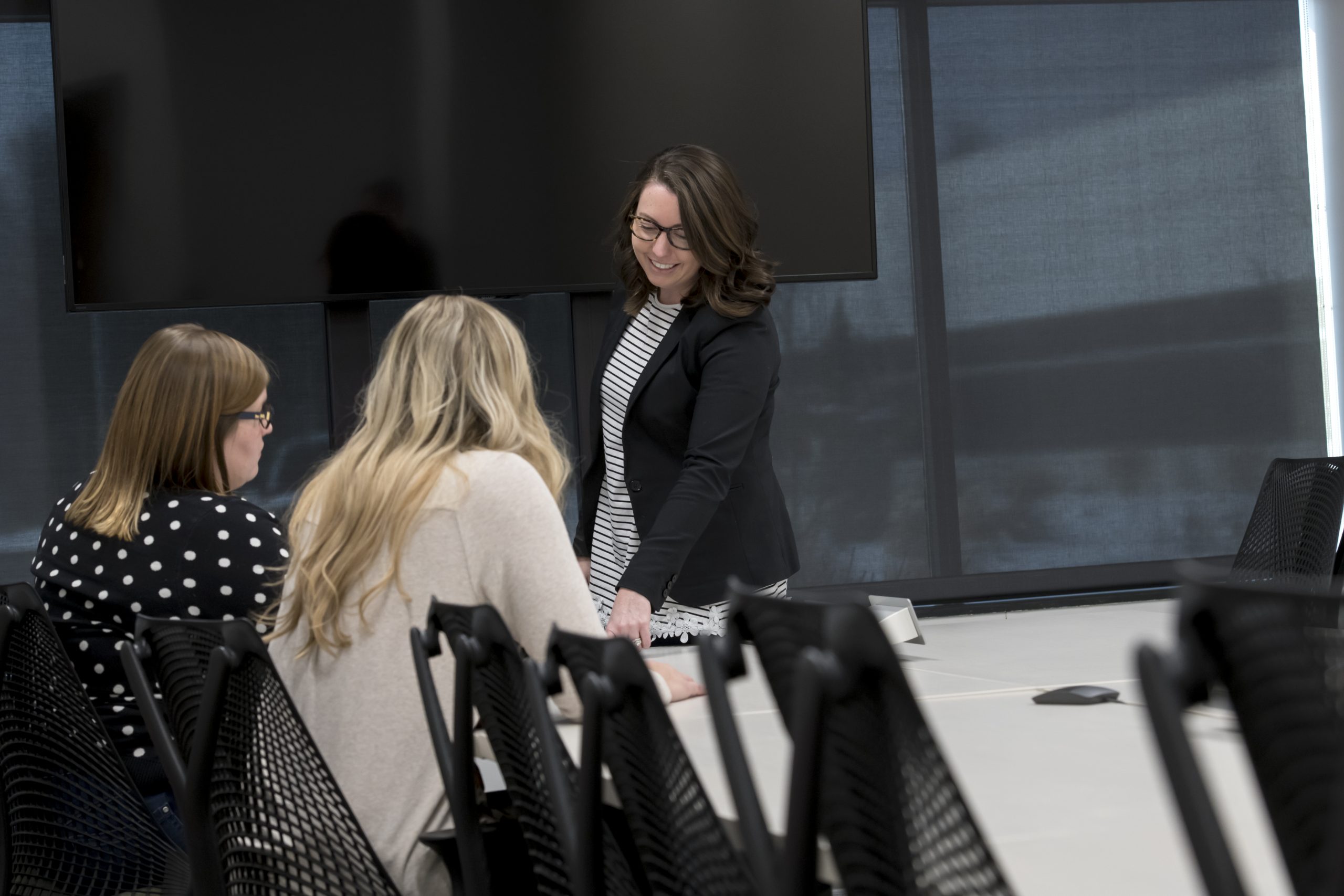 Design Collaborative team of three people collaborate together in a meeting room.
