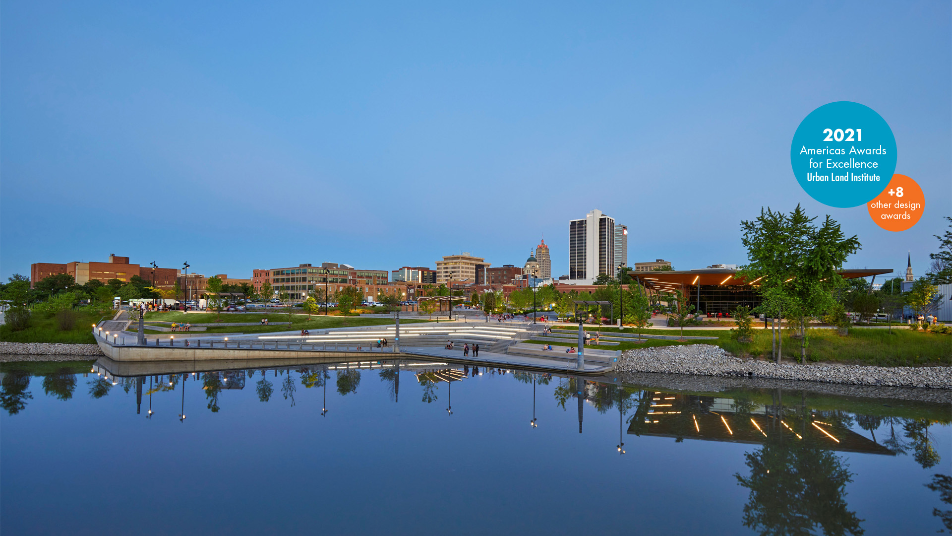 Promenade Park at dusk with reflections in the St Marys River and the Fort Wayne skyline in the background.