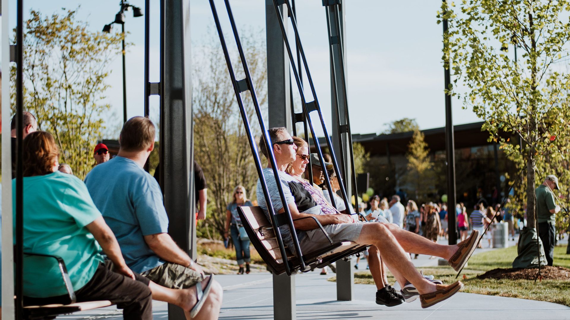 A couple sitting on a swing during an event at Promenade Park.