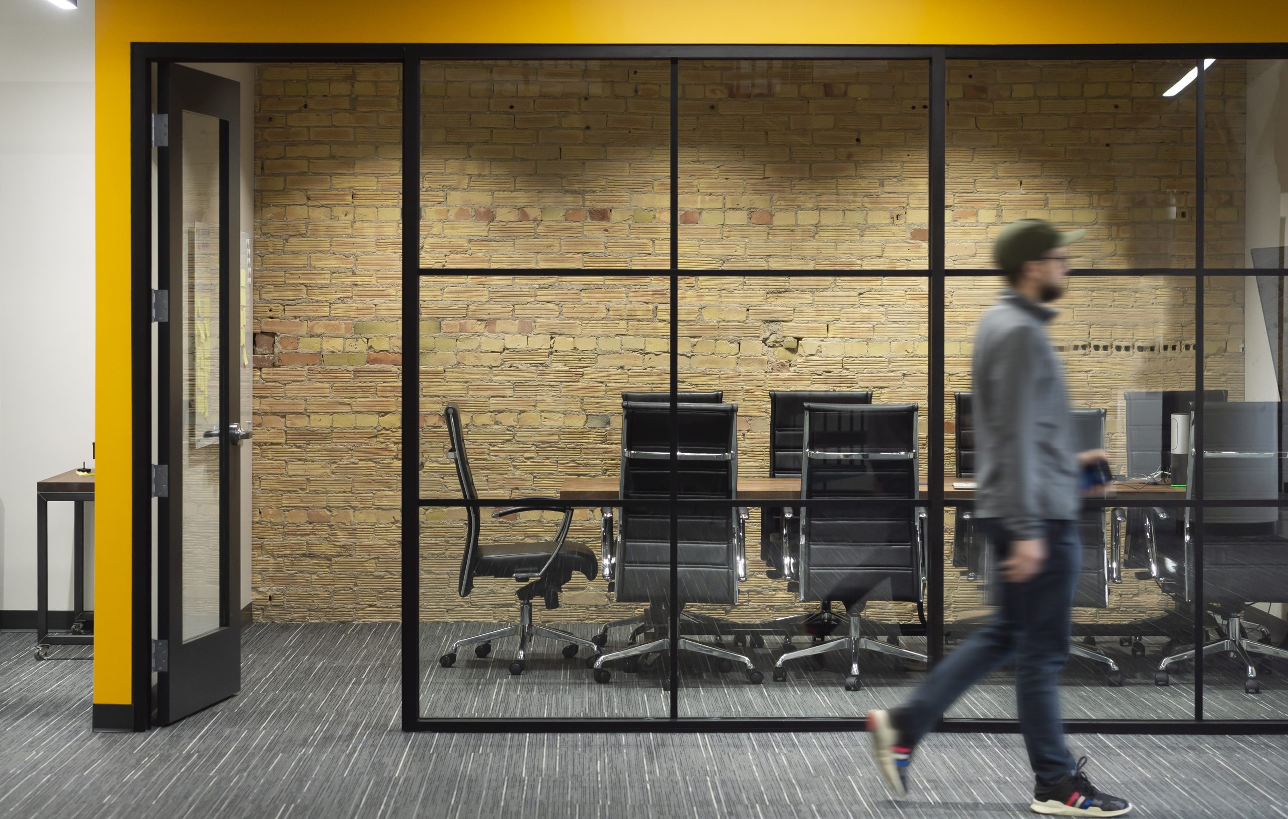 Staff Walking Past Glass Grid Conference Room