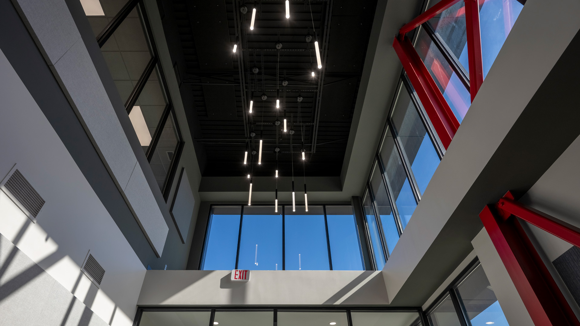Dark ceiling with dramatic lighting, and bold red accents.