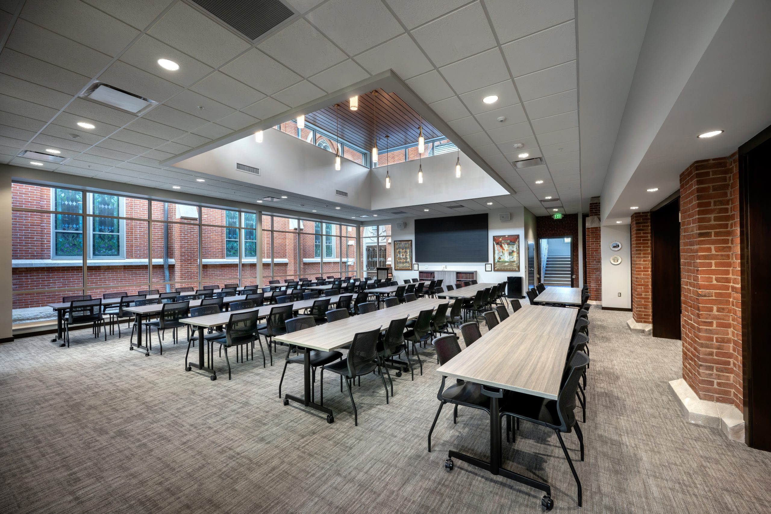 Conference room with large windows warm brick, and skylight ceiling.