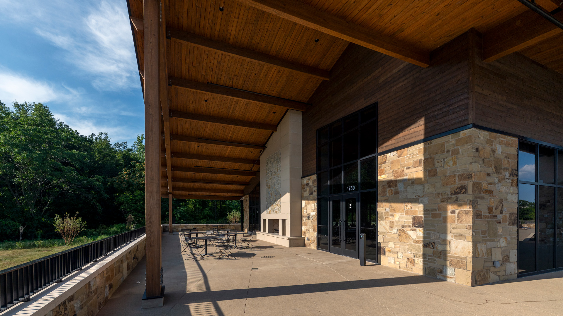 Franke Park Pavilion patio with a large wood awning and stone fireplace.
