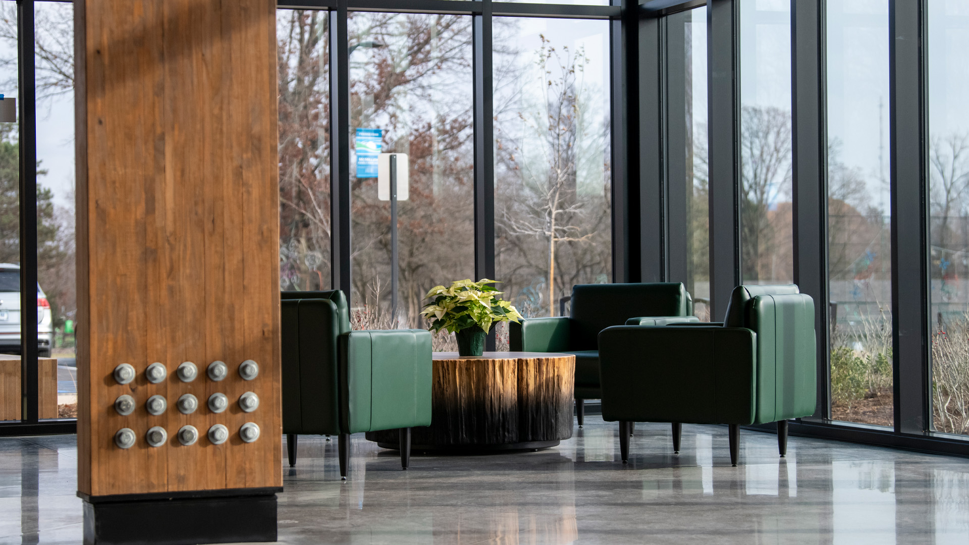 Green seating in lobby next to windows.