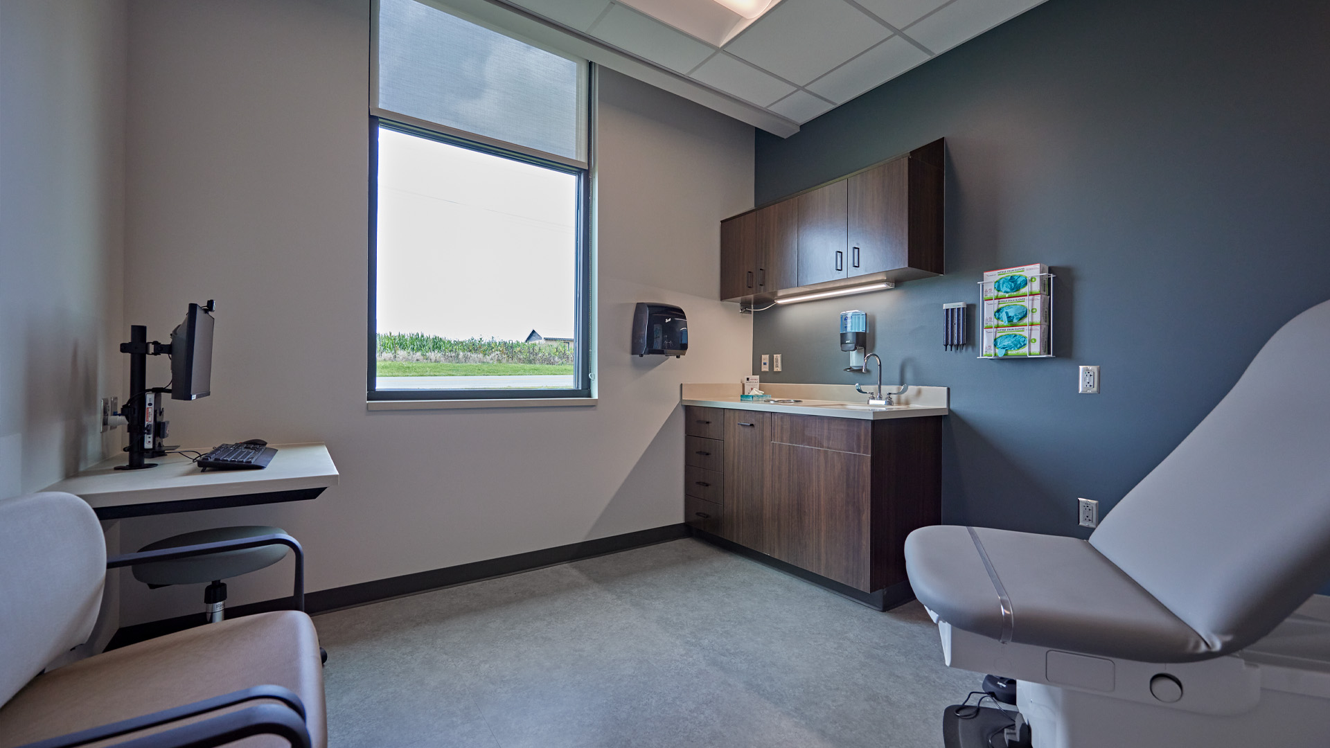 Exam room with wood casing and blue walls.