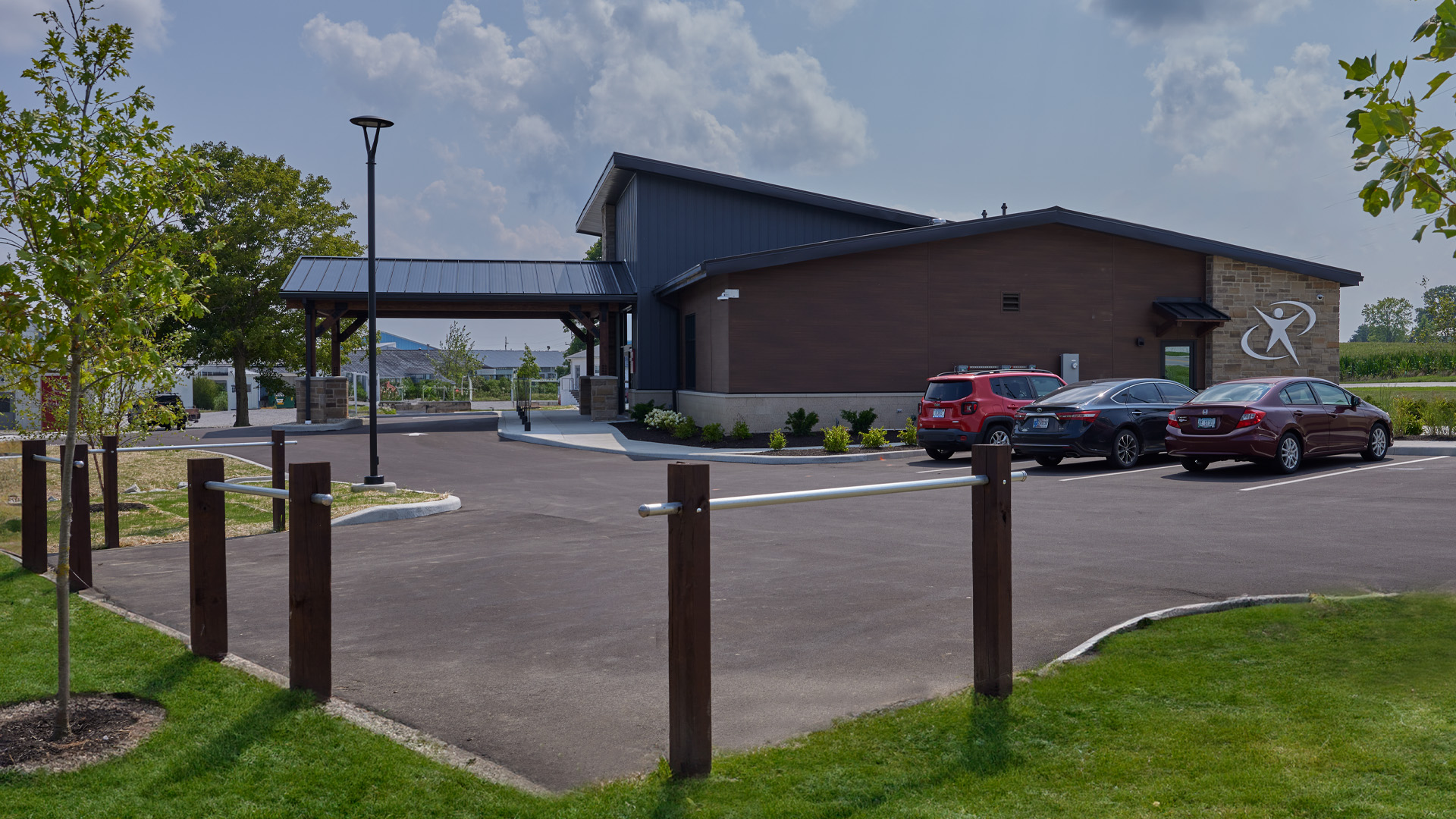Clinic exterior with large glass window feature, warm wood tones, and stone.