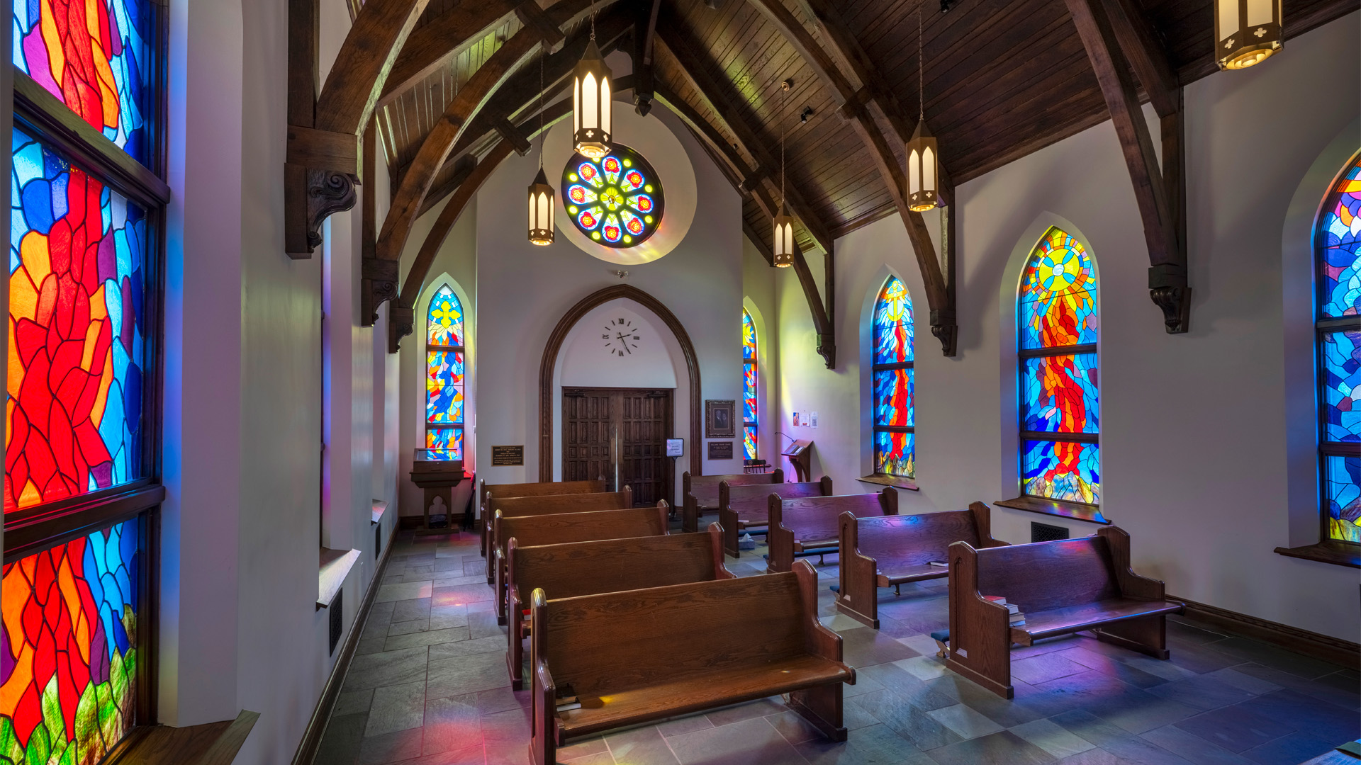 Indiana Wesleyan Prayer Chapel interior with stained glass windows and rows of pews.