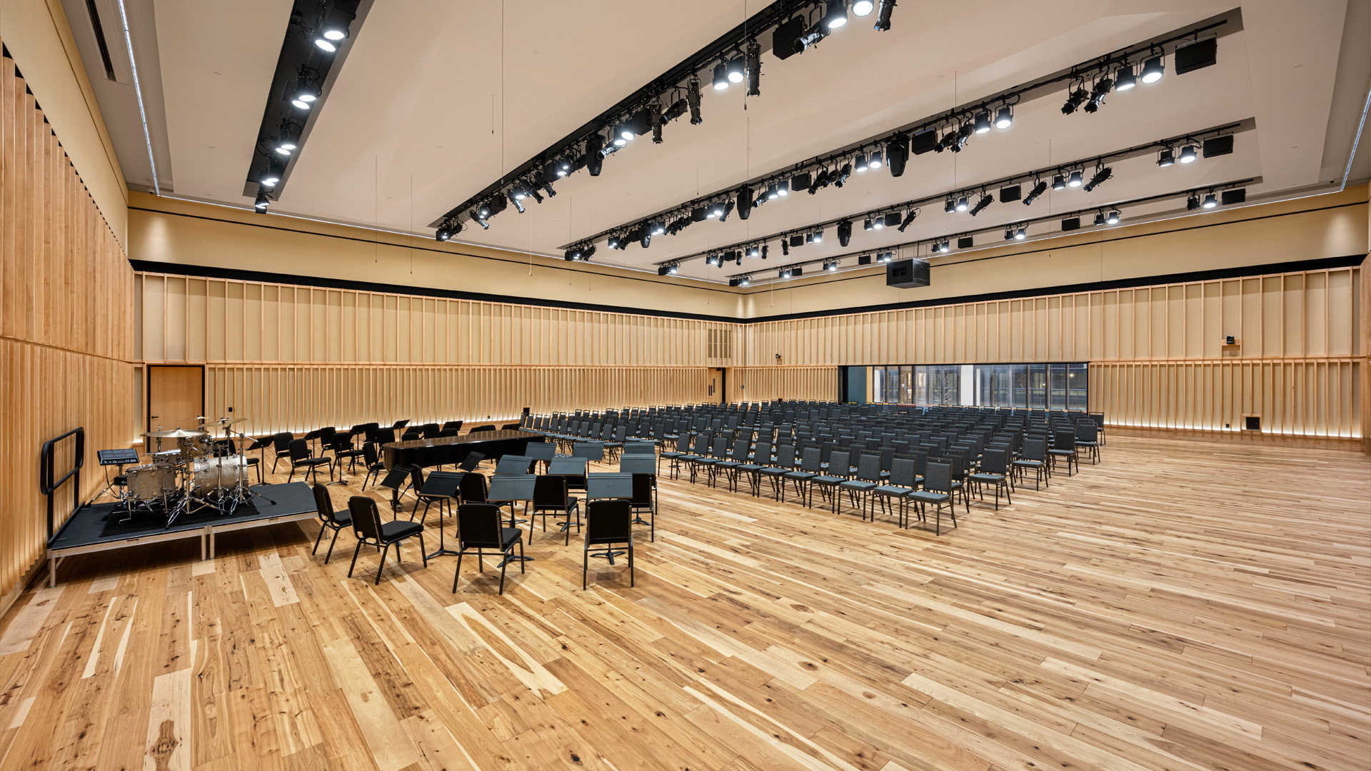 Auditorium performing arts center with unfixed seating and warm wood tones.