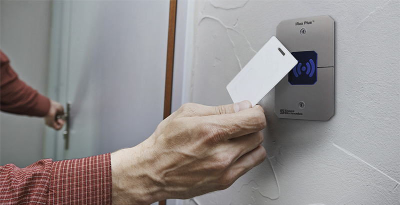 Hand Holding Key Card Against Scanner