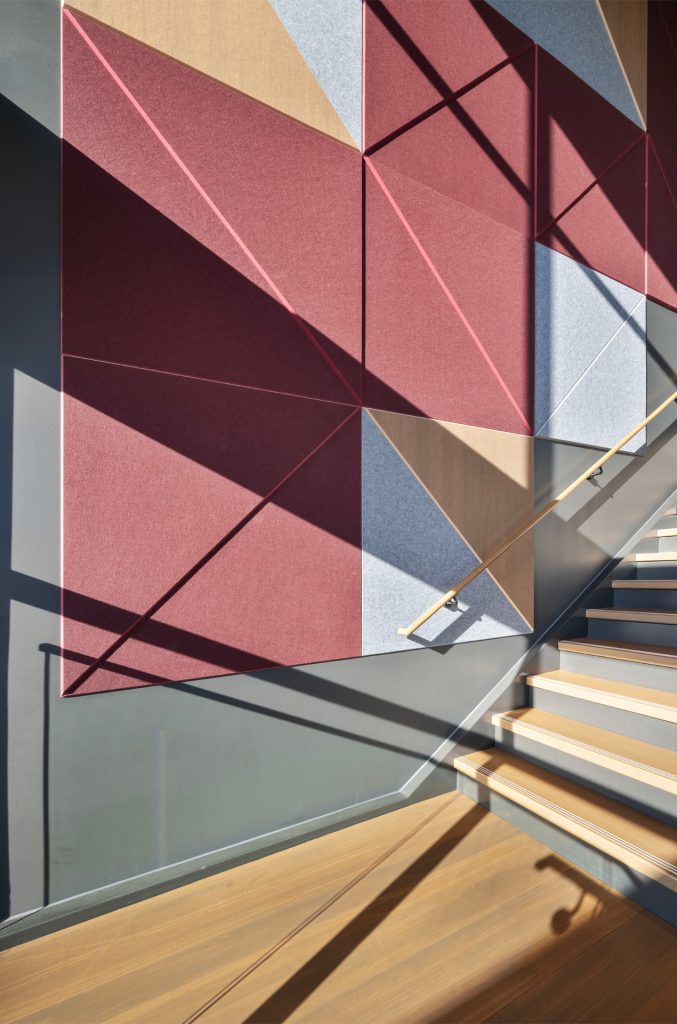 Stairwell in the Bippus State Bank Operations Center Lobby with a geometric pattern on the wall and sunlight streaming in.