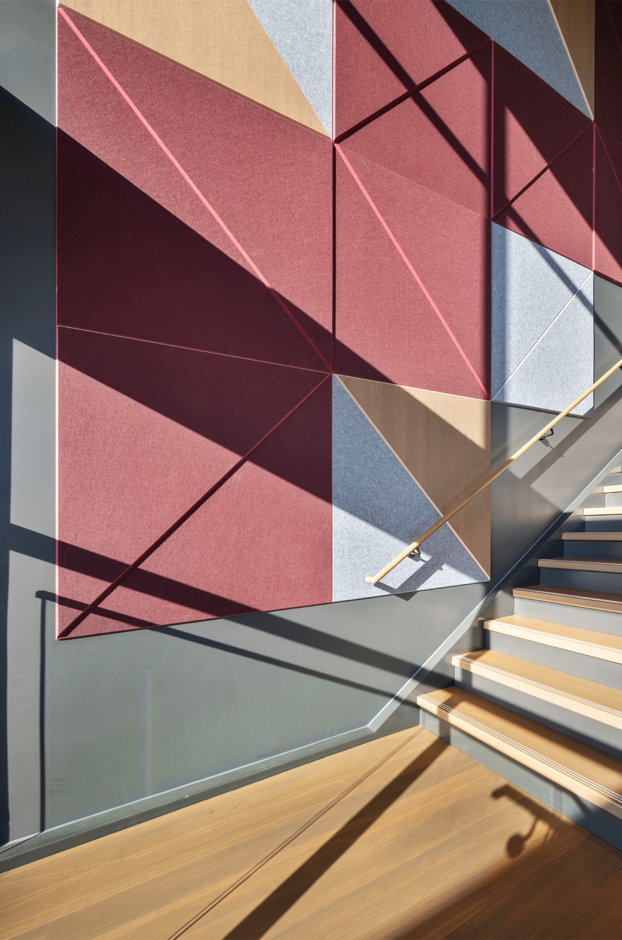 Stairwell in the Bippus State Bank Operations Center Lobby with a geometric pattern on the wall and sunlight streaming in.