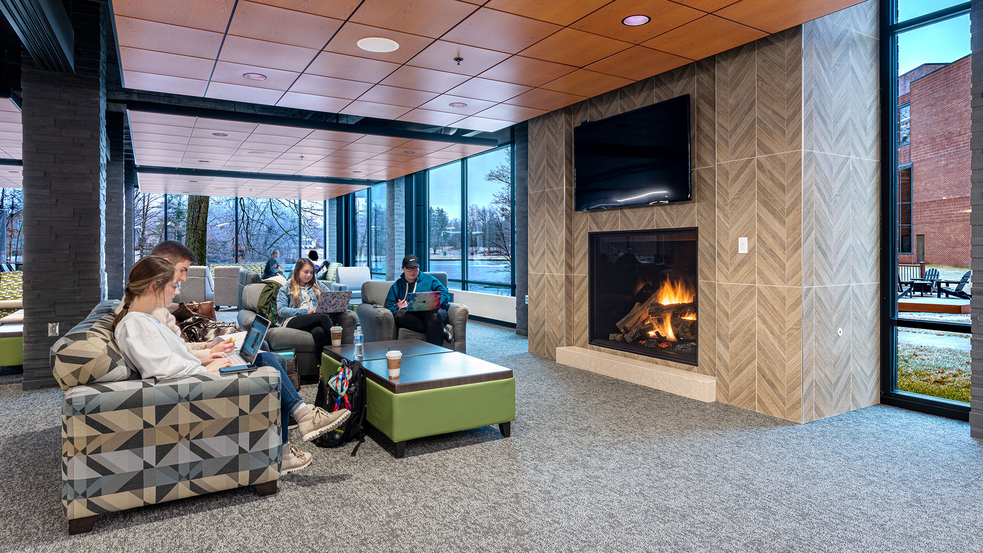 College students sitting in front of fireplace