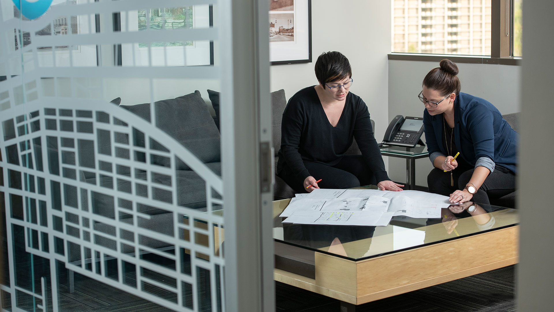 Two women reviewing document in conference room