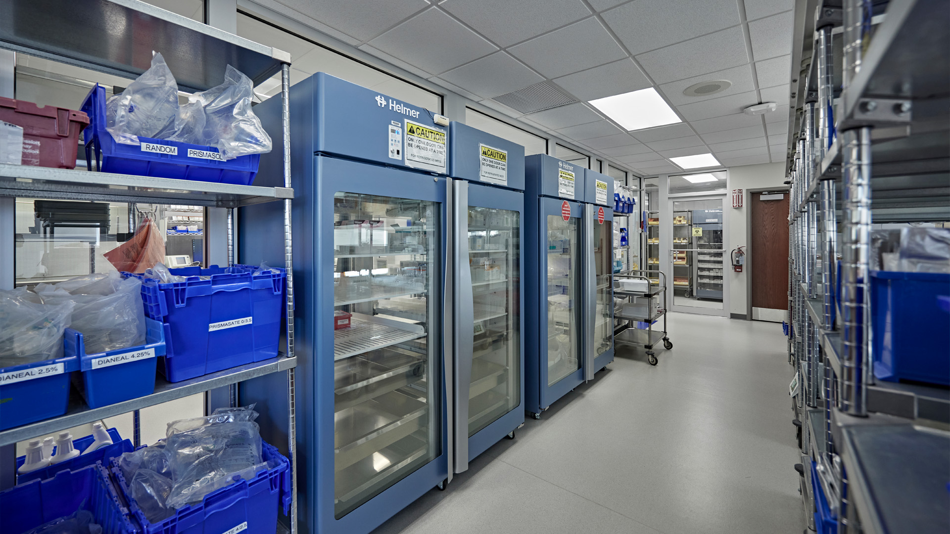 Safe pharmacy storage room with blue fridge/freezer storage and blue bins.