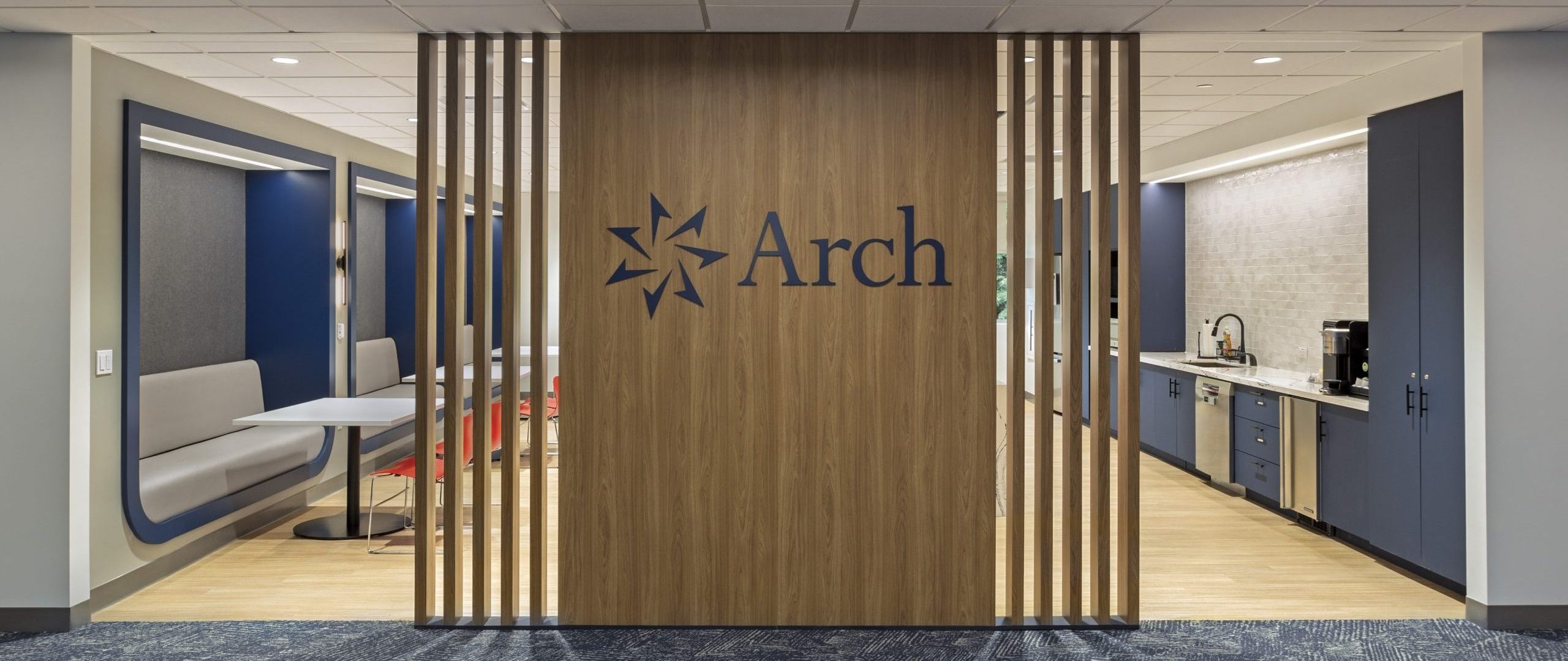 Community hub entrance with warm wood tone patrician wall and large logo branding.