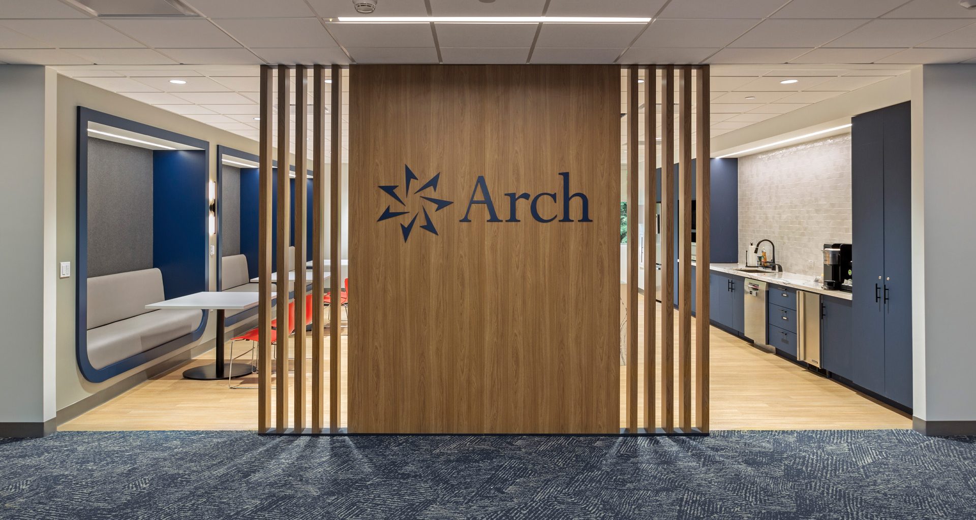 Community hub entrance with warm wood tone patrician wall and large logo branding.
