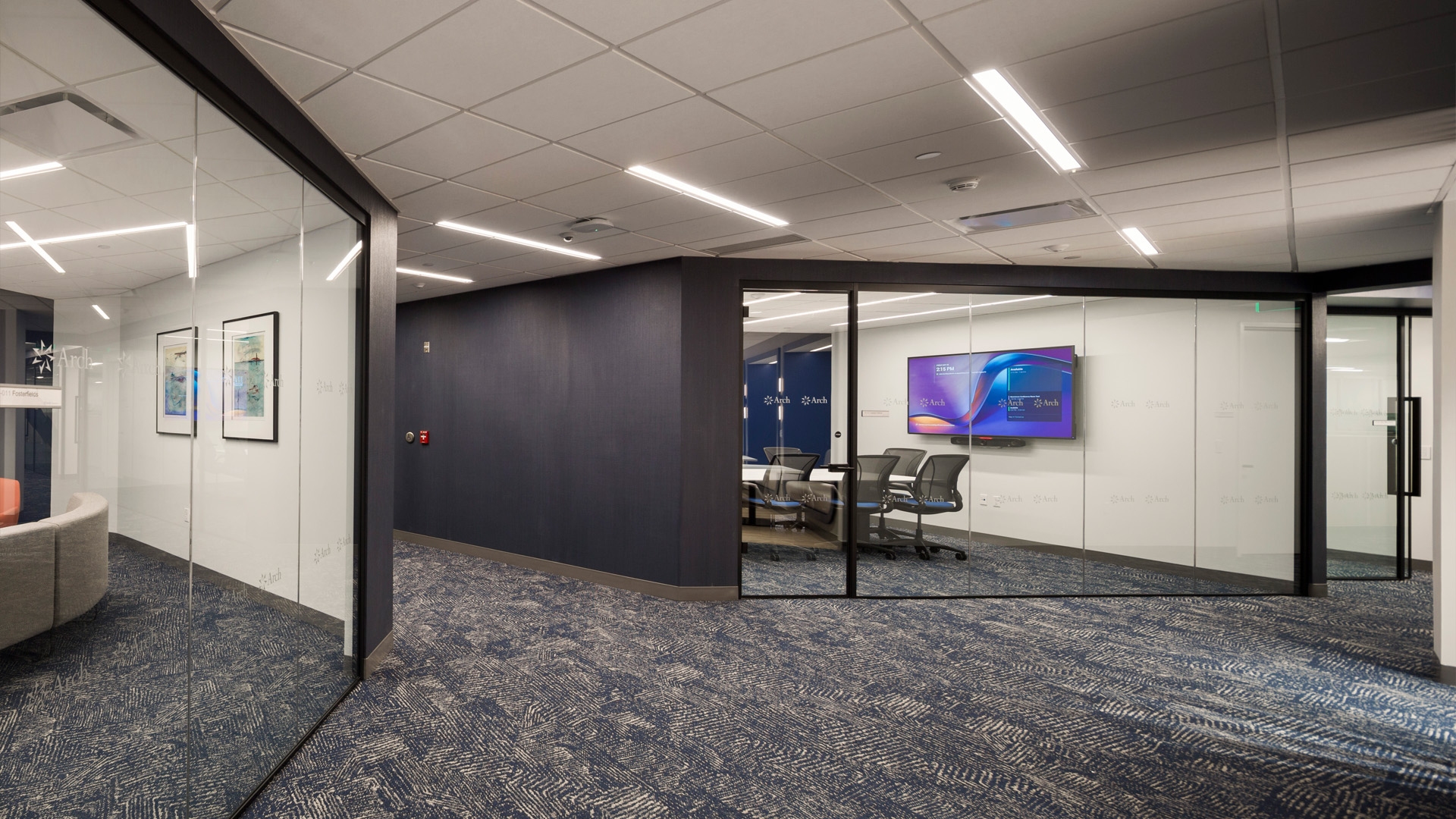 Hall in corporate office with conference rooms, highly visible with glass.