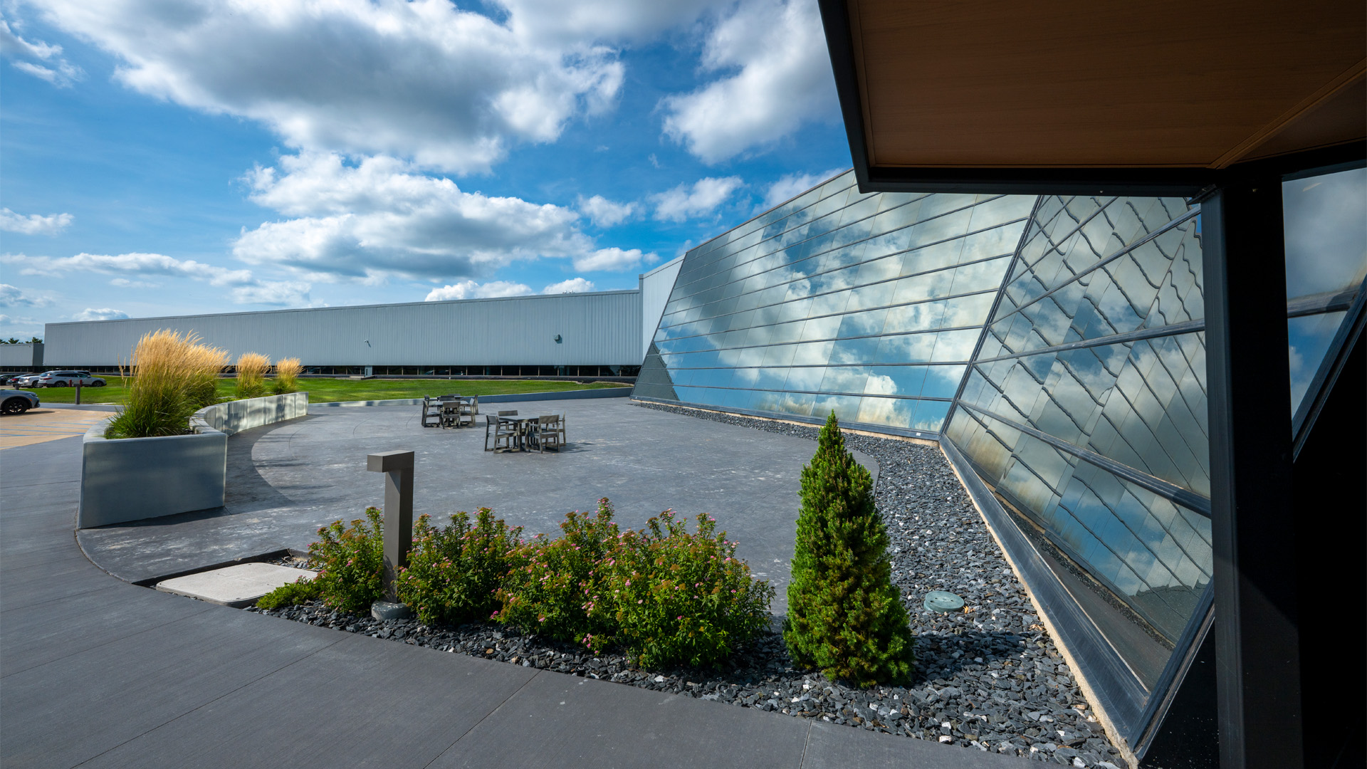 Formula Boats Headquarters, a large window-covered building reflecting the sky with a patio in front.
