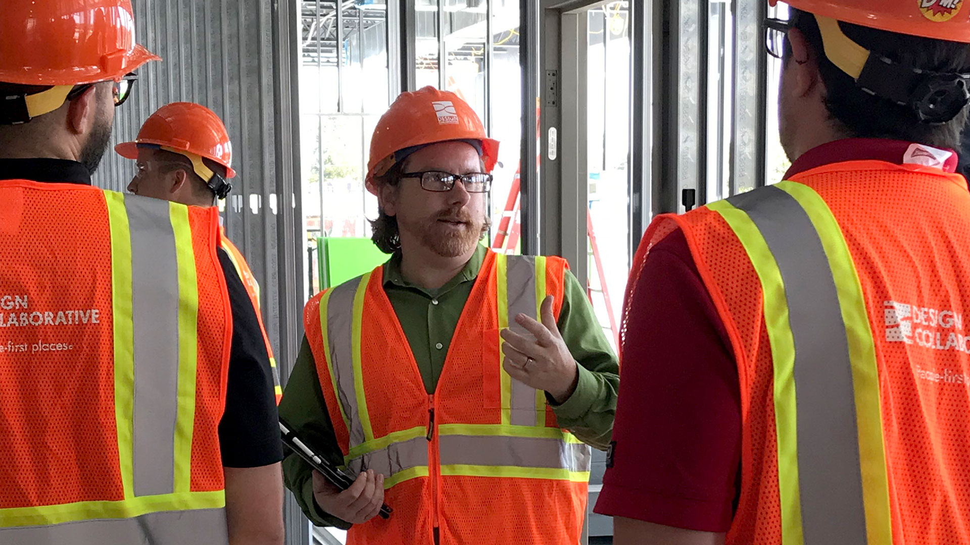 Three people talking on a job site