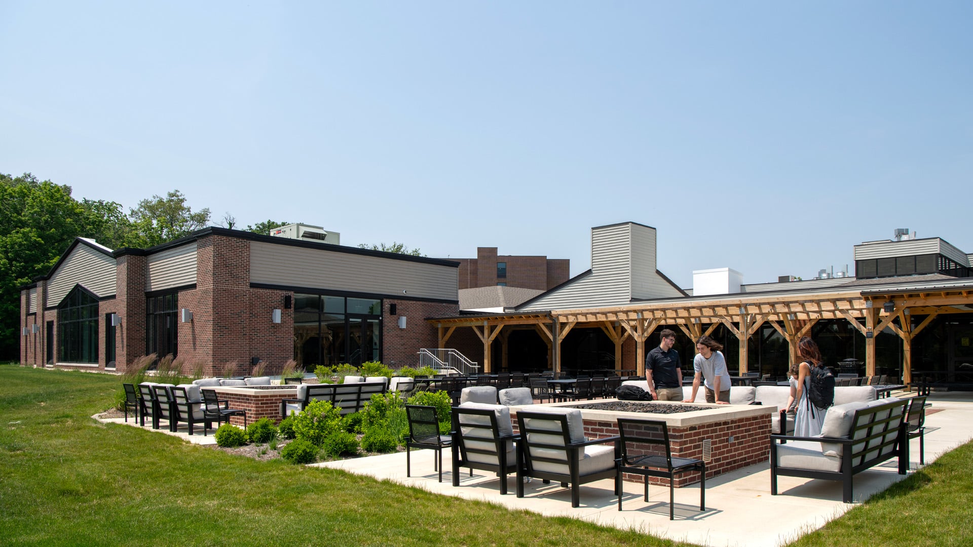Students relaxing in the outdoor seating of Taylor University's Hodson Dining building.