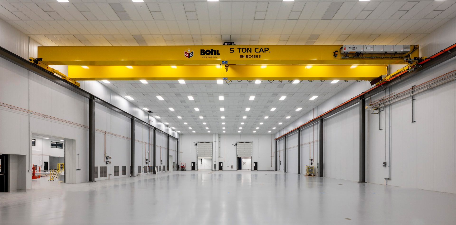 Large industrial room with yellow beams.