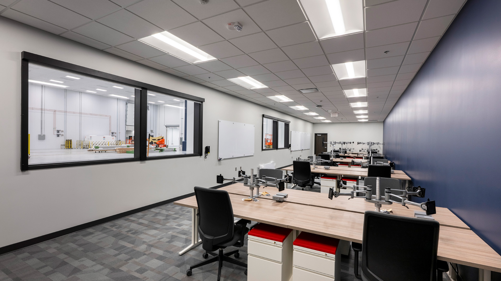 Collaborative office space overlooking large industrial room.