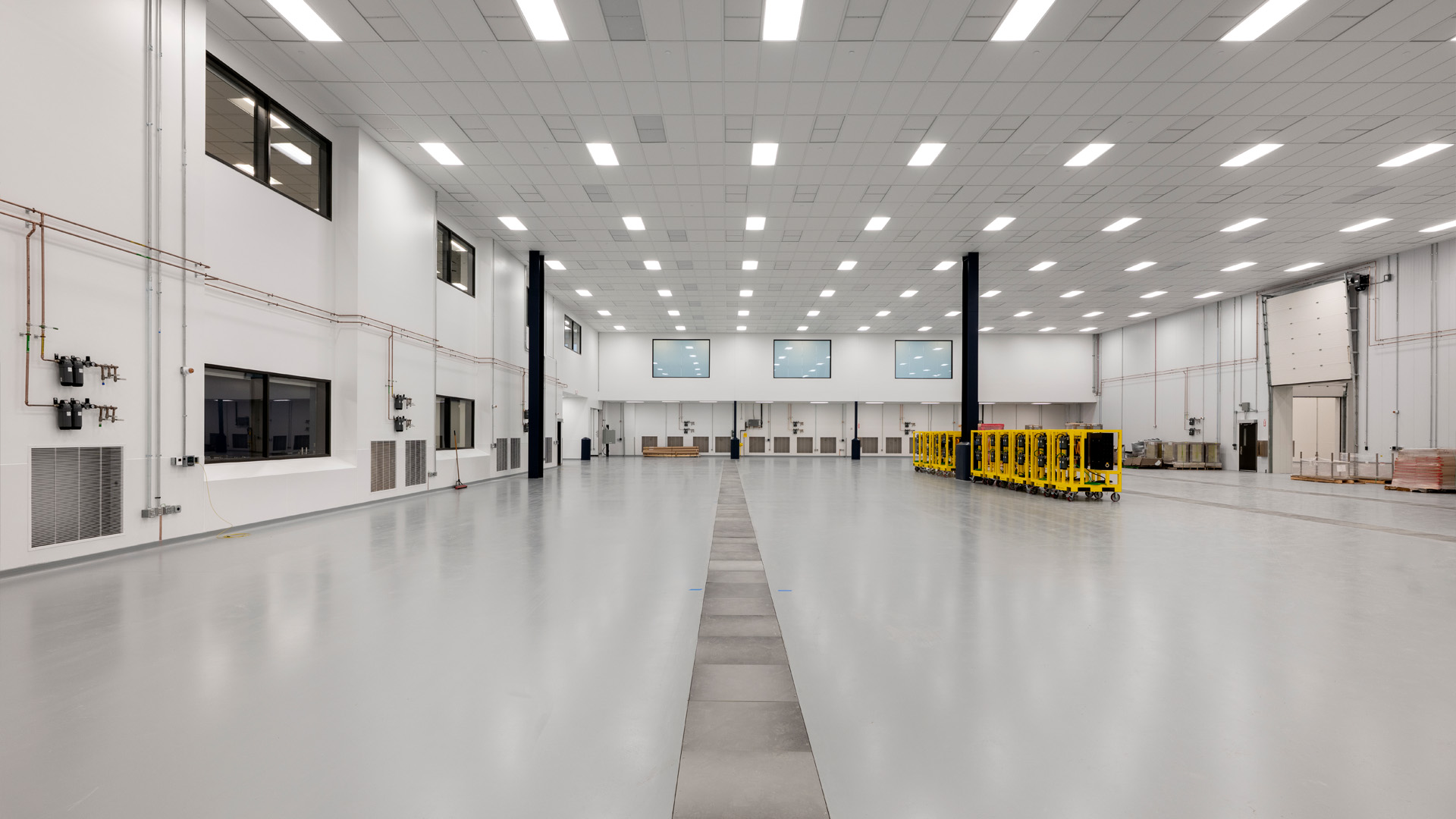 Large industrial room with yellow beams.