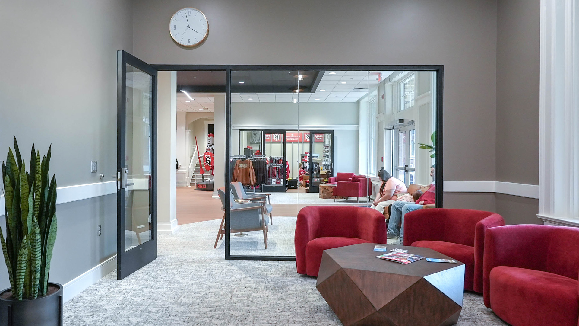 Grace College's Westminster Hall with statement red comfy chairs and a wood coffee table.