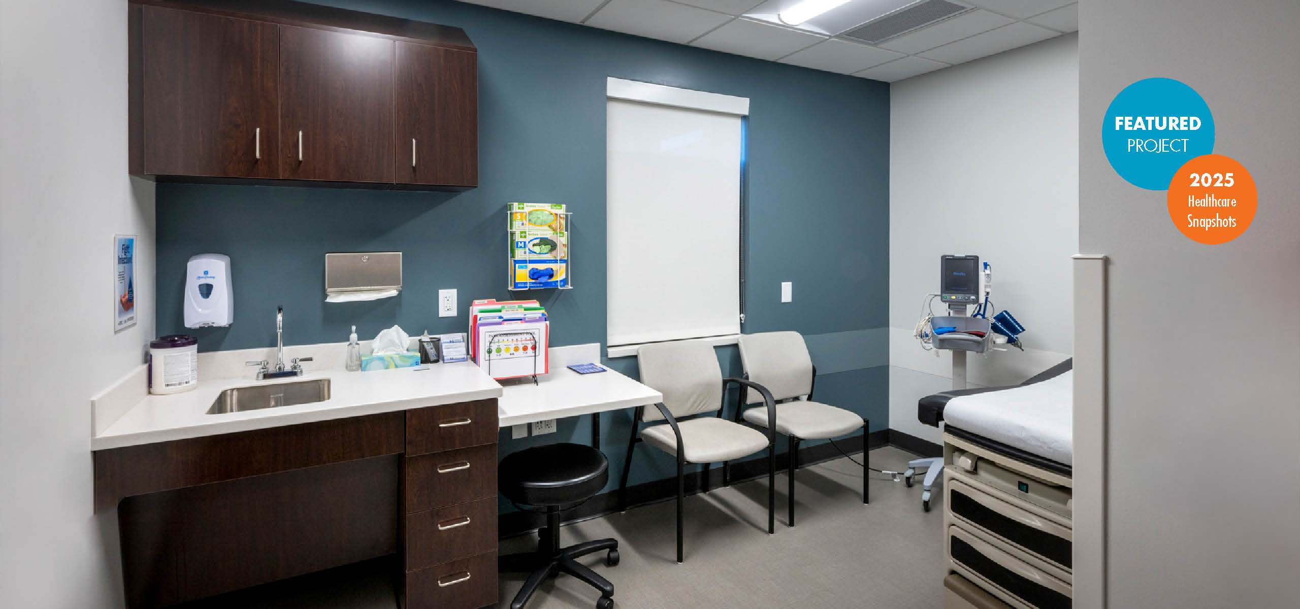 Exam room with blue feature wall and multiple seating options for provider and patient. with award graphic.