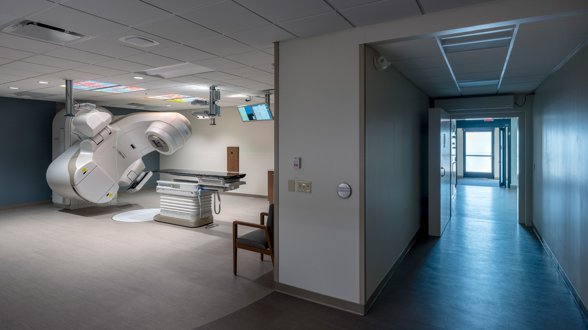 Radiation oncology clinic linear accelerator room with hallway views.