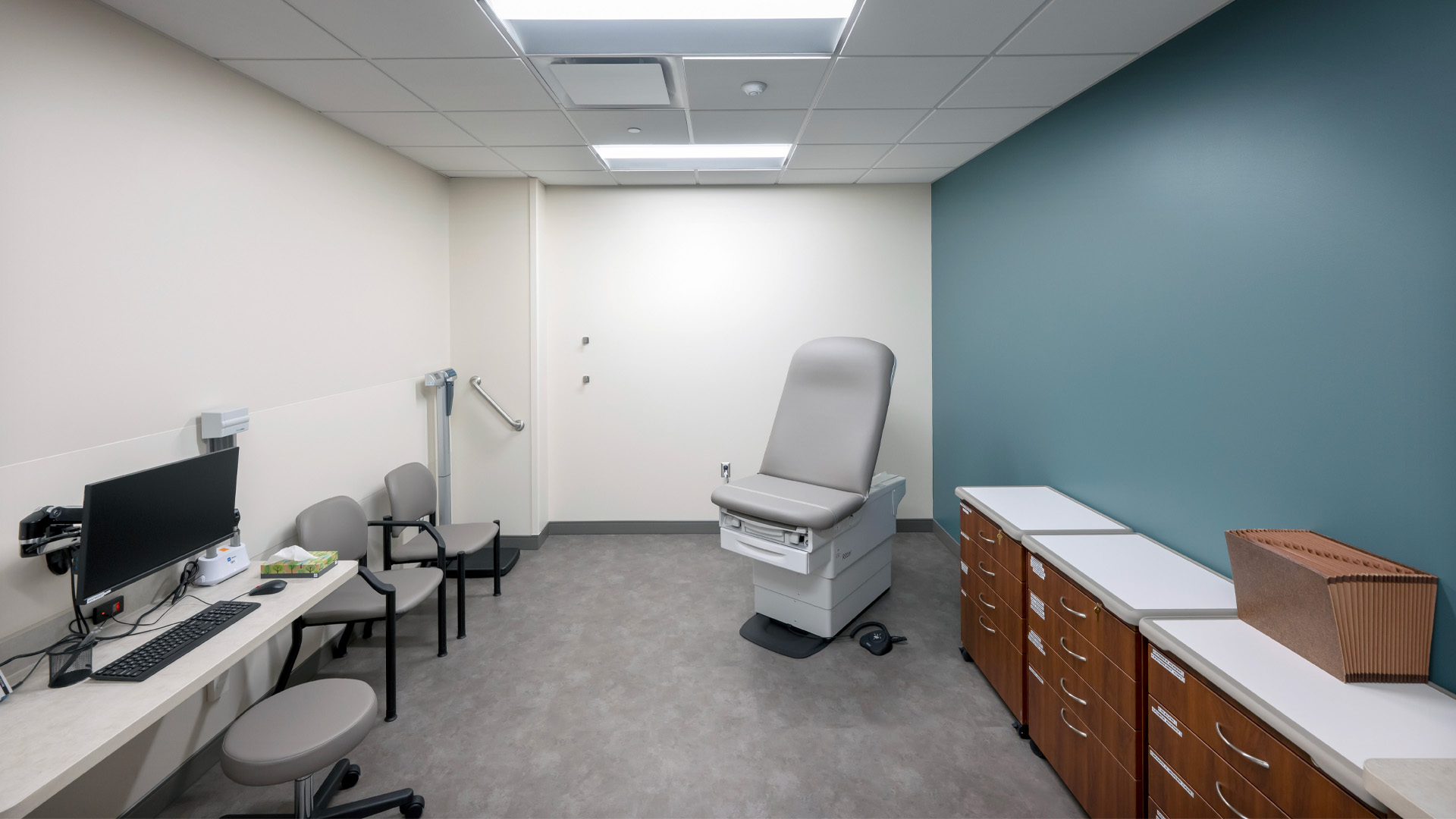 Patient room with blue wall and wood cabinets at Parkview Physicians Group's Warsaw Clinic.