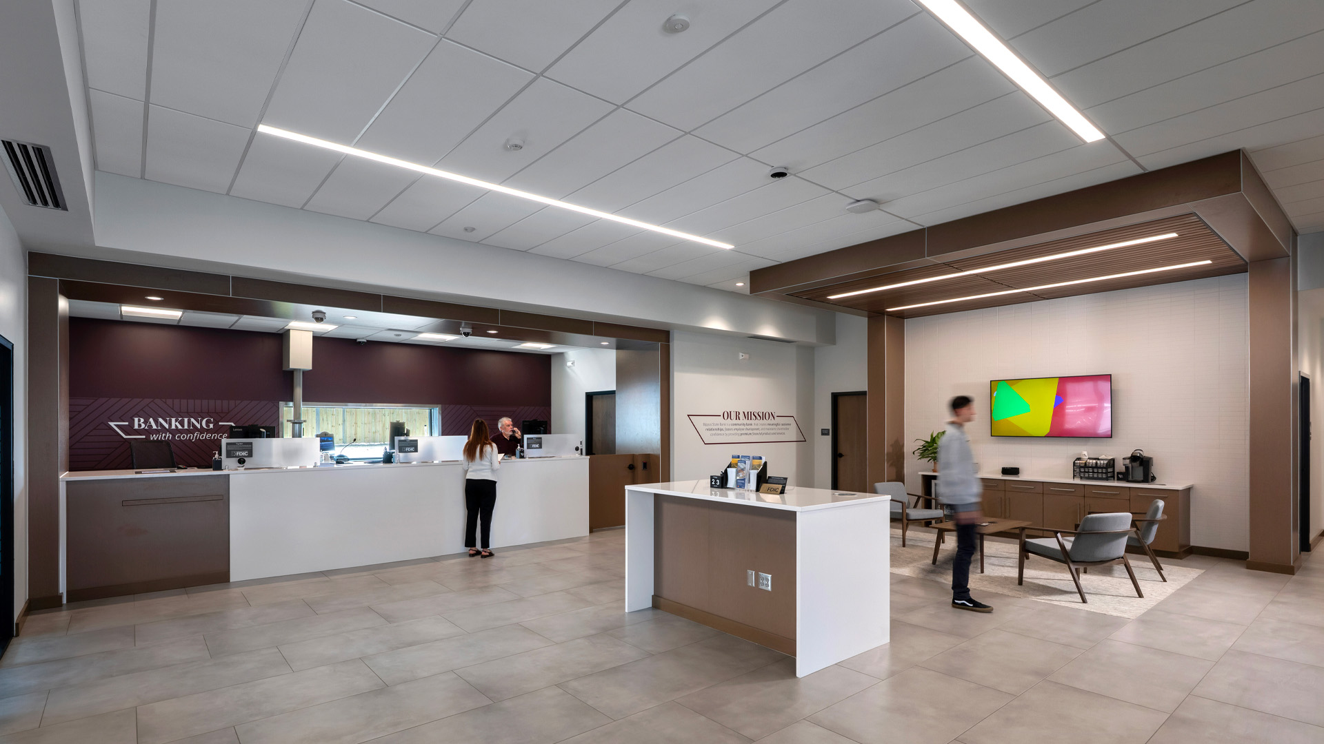 People work and walk through in the Bippus State Bank Fort Wayne Branch open concept lobby.