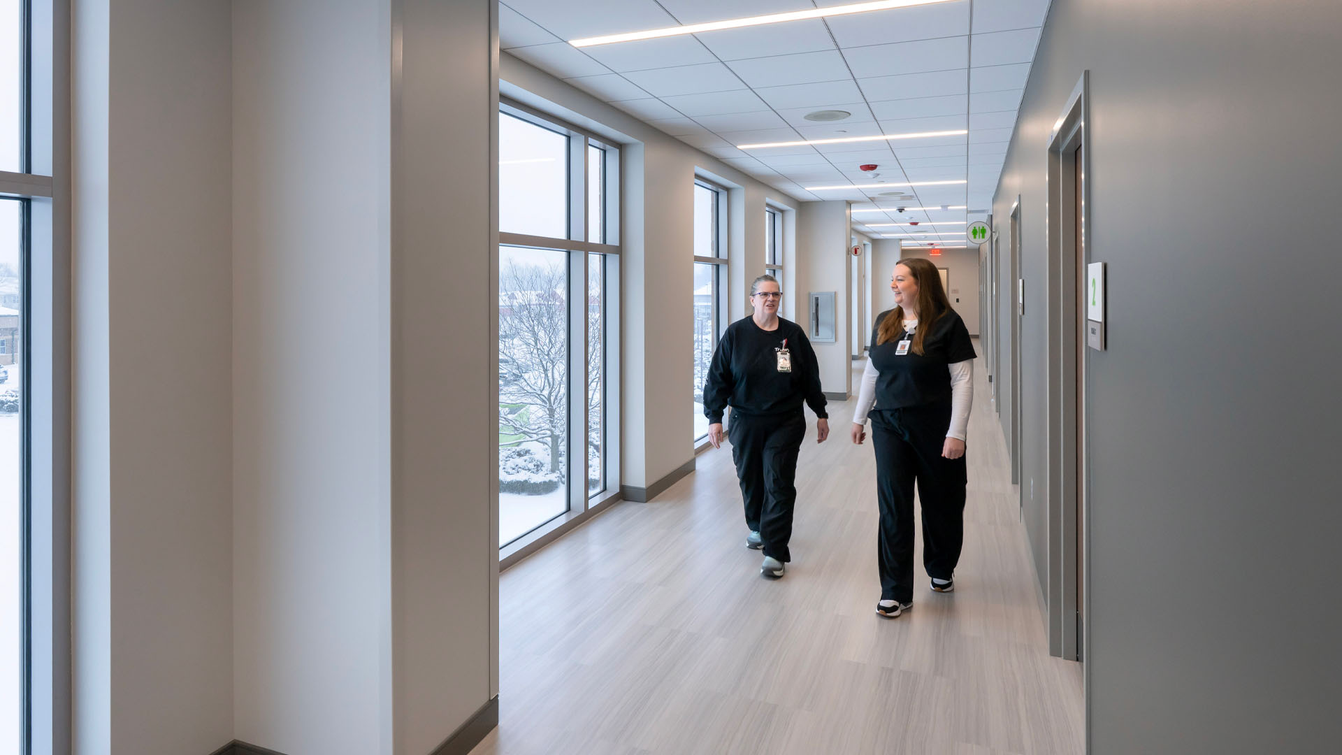 Nurses walk down hallway at Parkview Southwest HOD Clinic with calming green walls and plenty of natural light.
