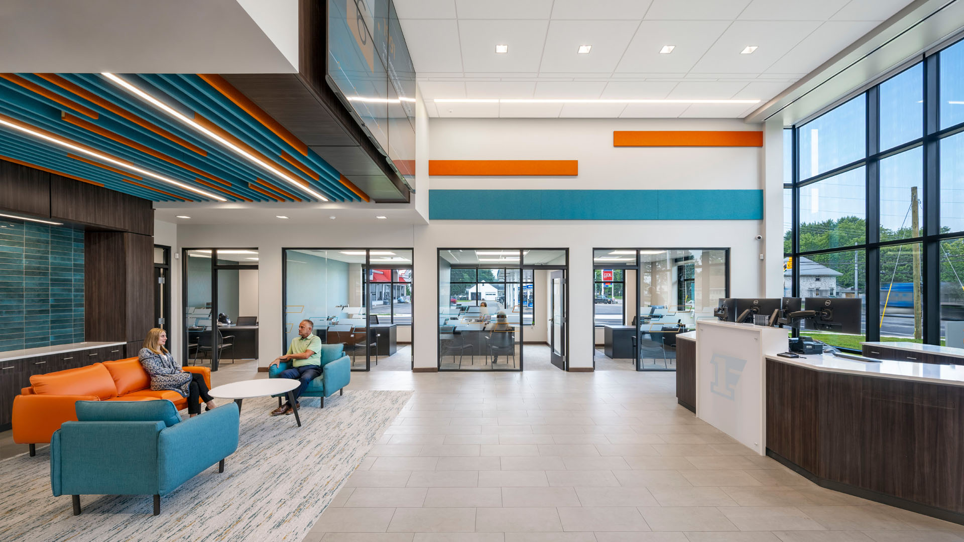 First Federal Bank Van Wert Branch lobby with bright orange and blue branding, video wall, and lighting design.
