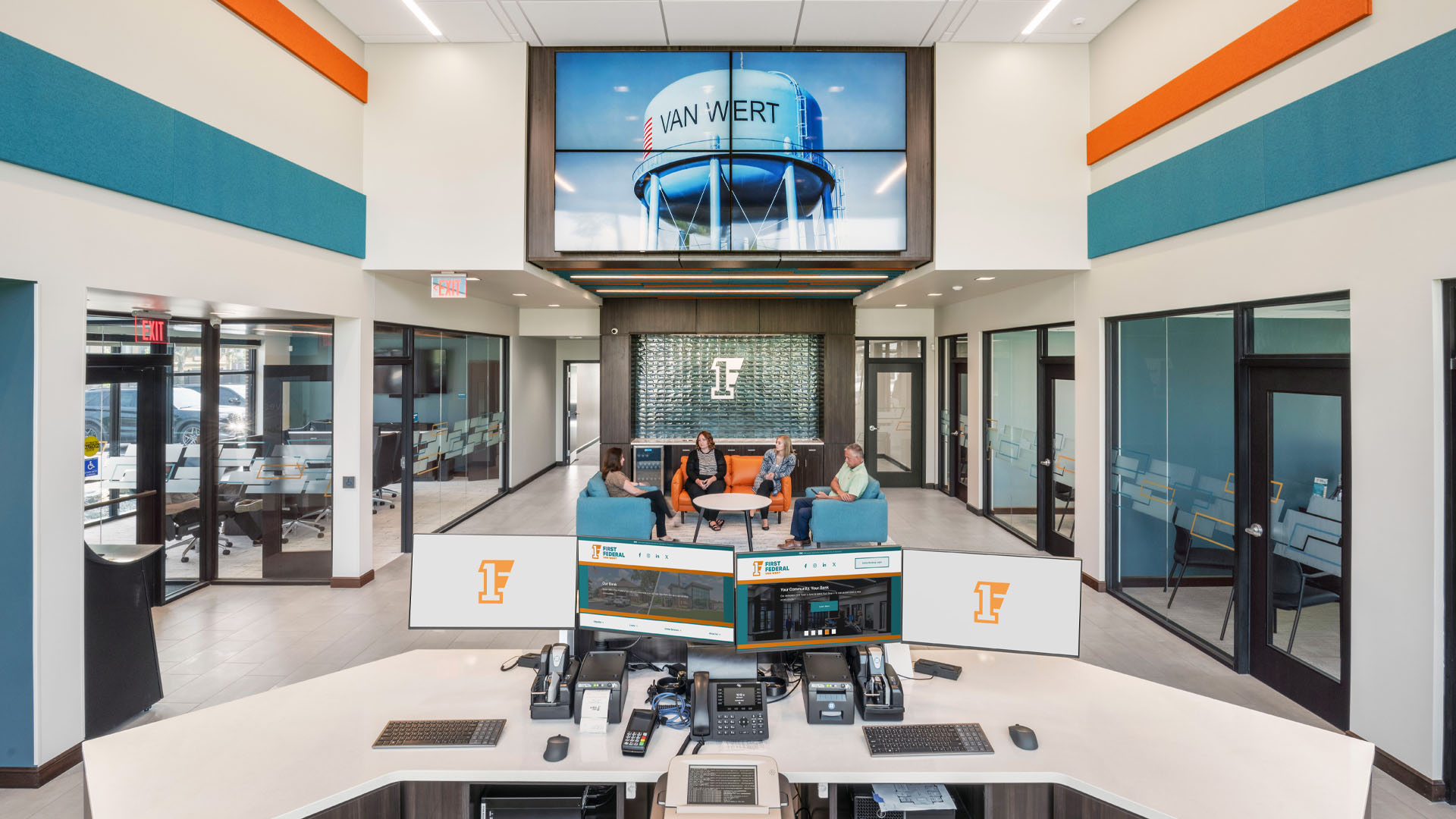 First Federal Bank Van Wert Branch lobby with bright orange and blue branding, video wall, and lighting design.