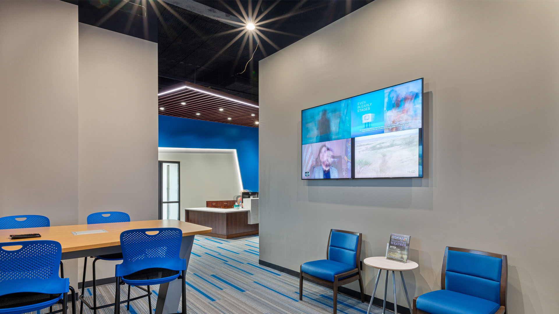 Break room at the Quincy Broadcasting WGEM news studio with blue accents, bold lighting, and an open office layout.