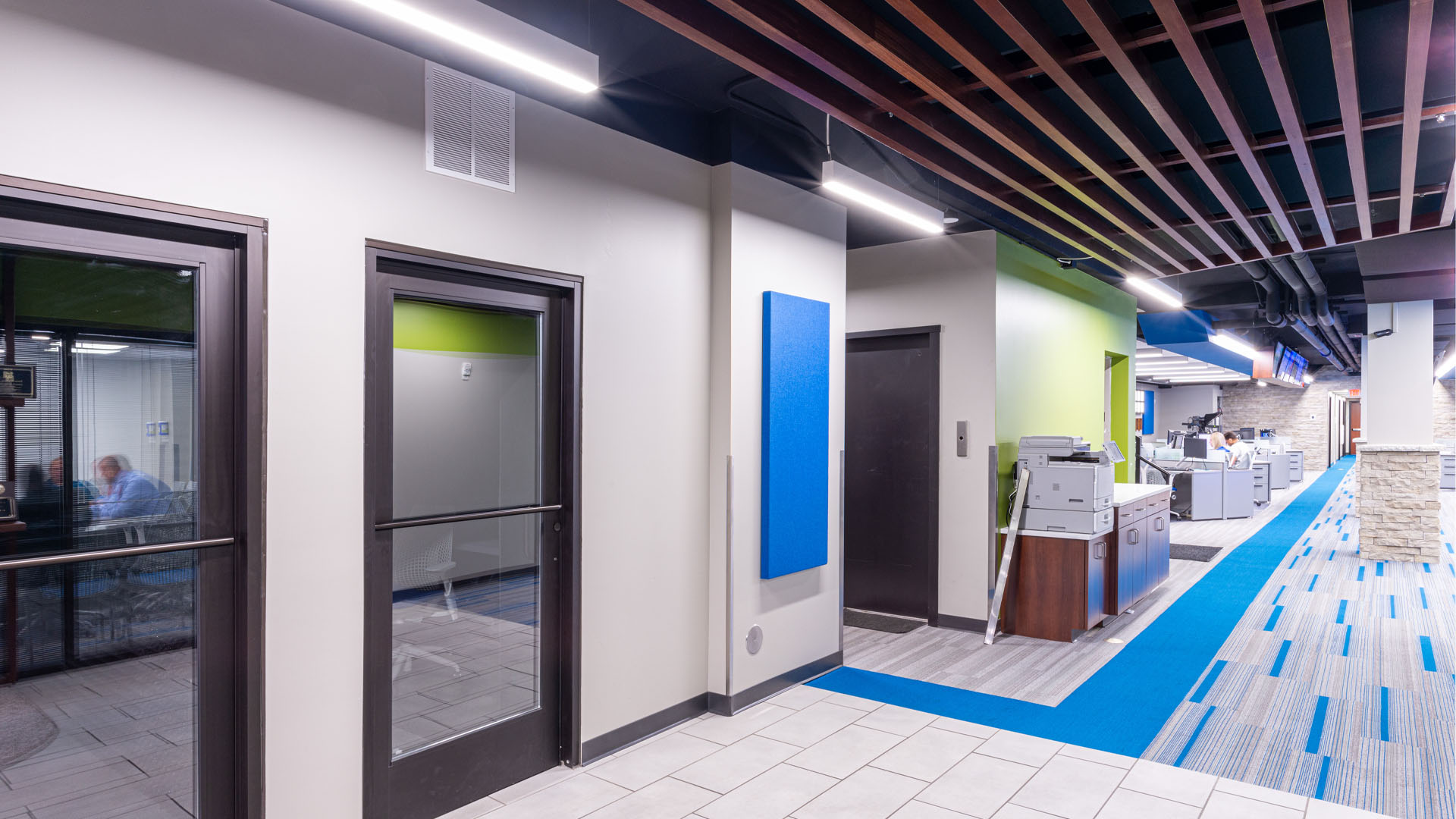 Quincy Broadcasting WGEM news studio hallway with decorative blue accents, strong lines, and an open office layout.