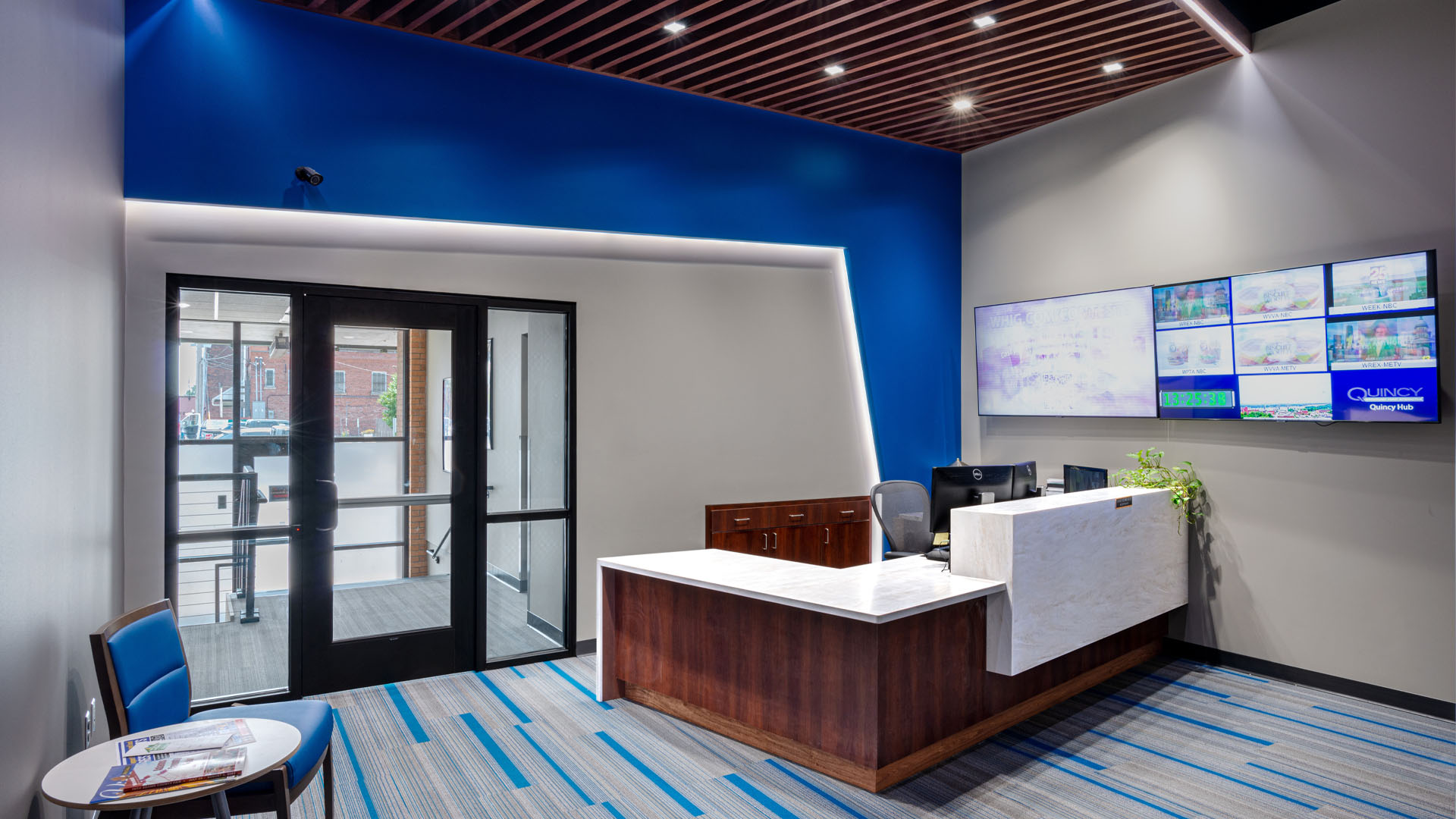 Front desk at Quincy Broadcasting WGEM news studio with decorative blue accents and bold lighting.