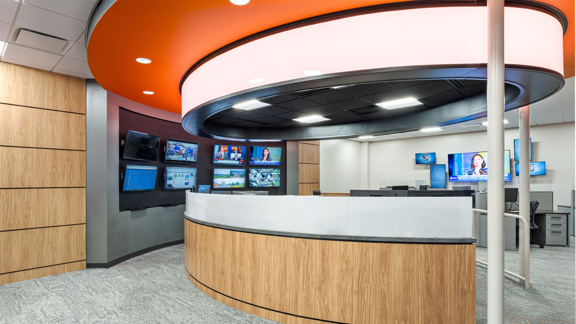 Quincy Broadcasting WSIL-TV Newsroom with colorful circular orange ceiling details and an open office layout.