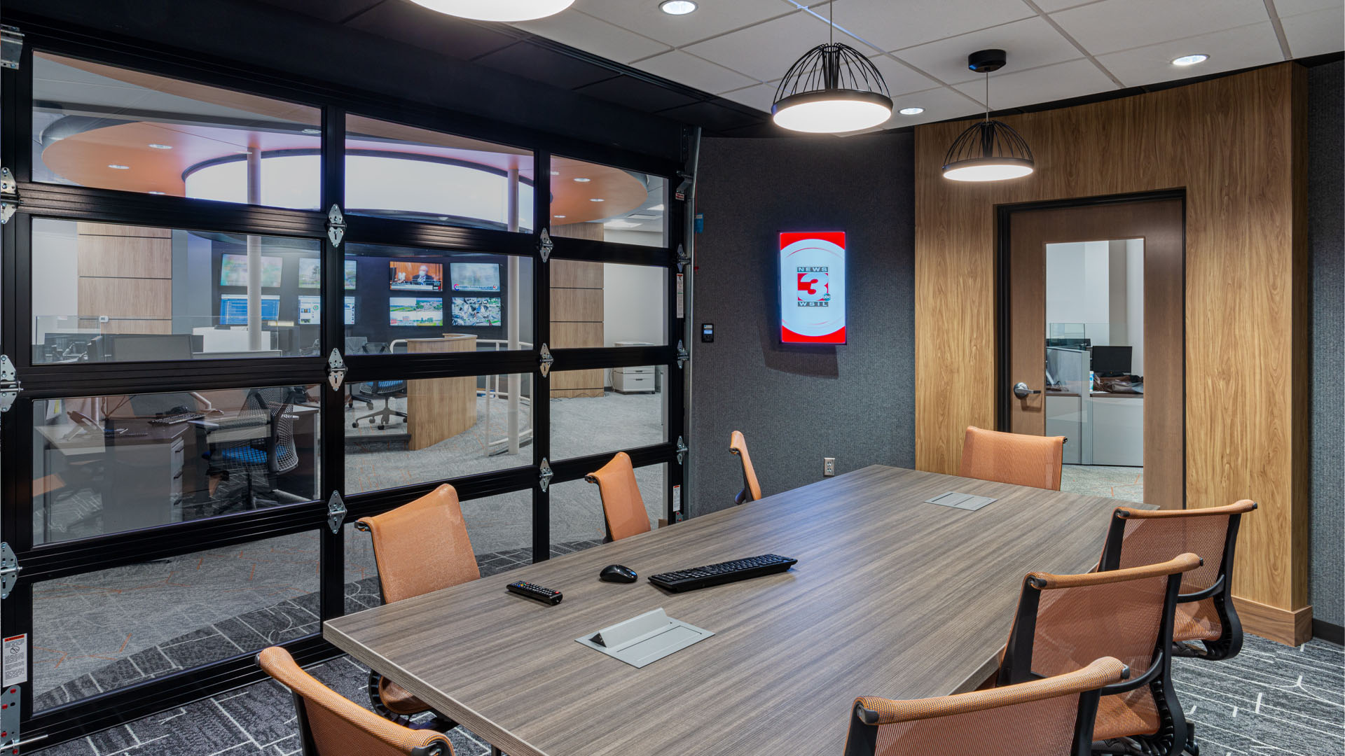 Conference room at Quincy Broadcasting WSIL-TV Newsroom with open glass garage door, wood accents, and unique lighting.