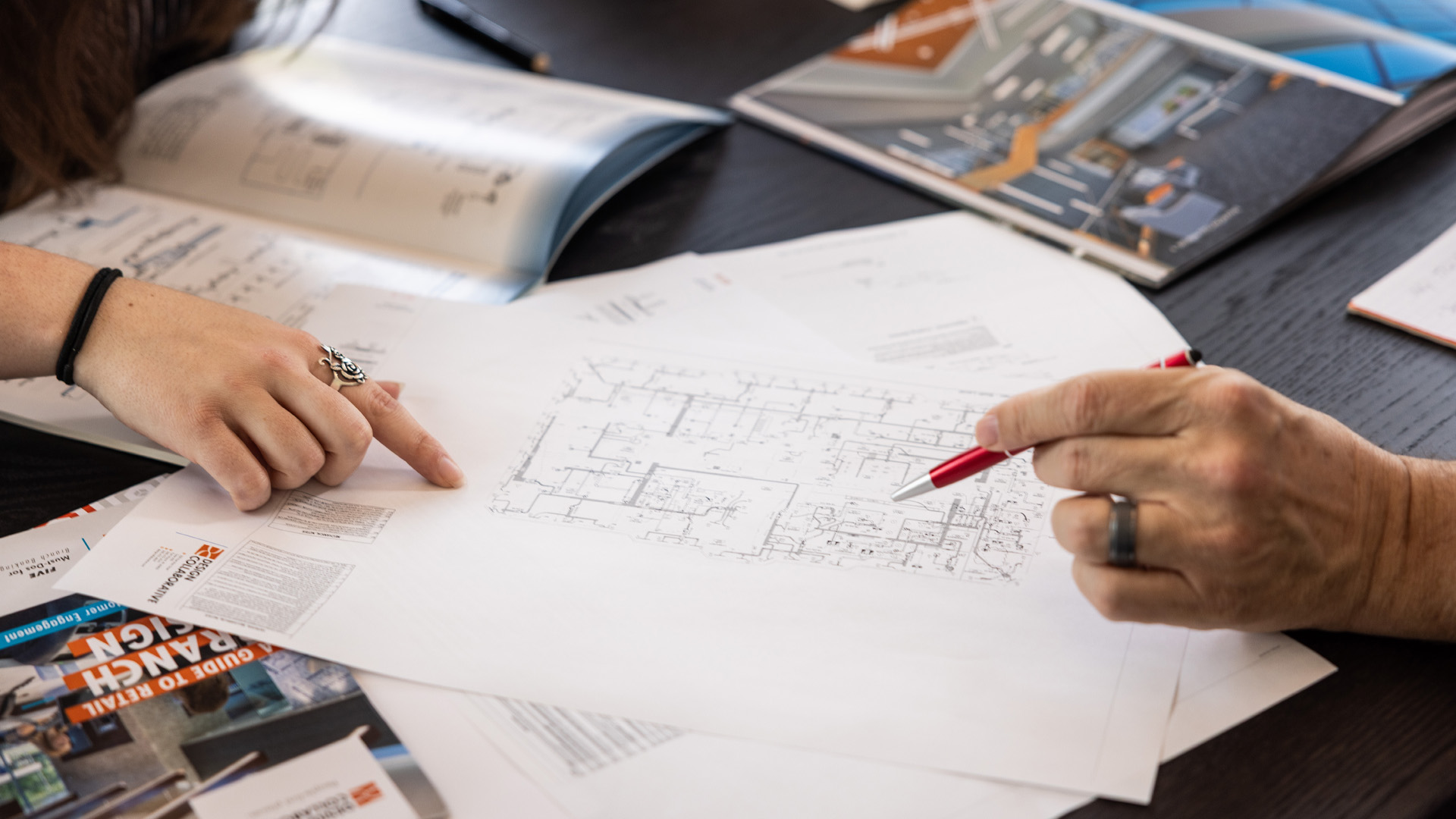 Design Collaborative architects in Charlotte North Carolina make notes on a floor plan.