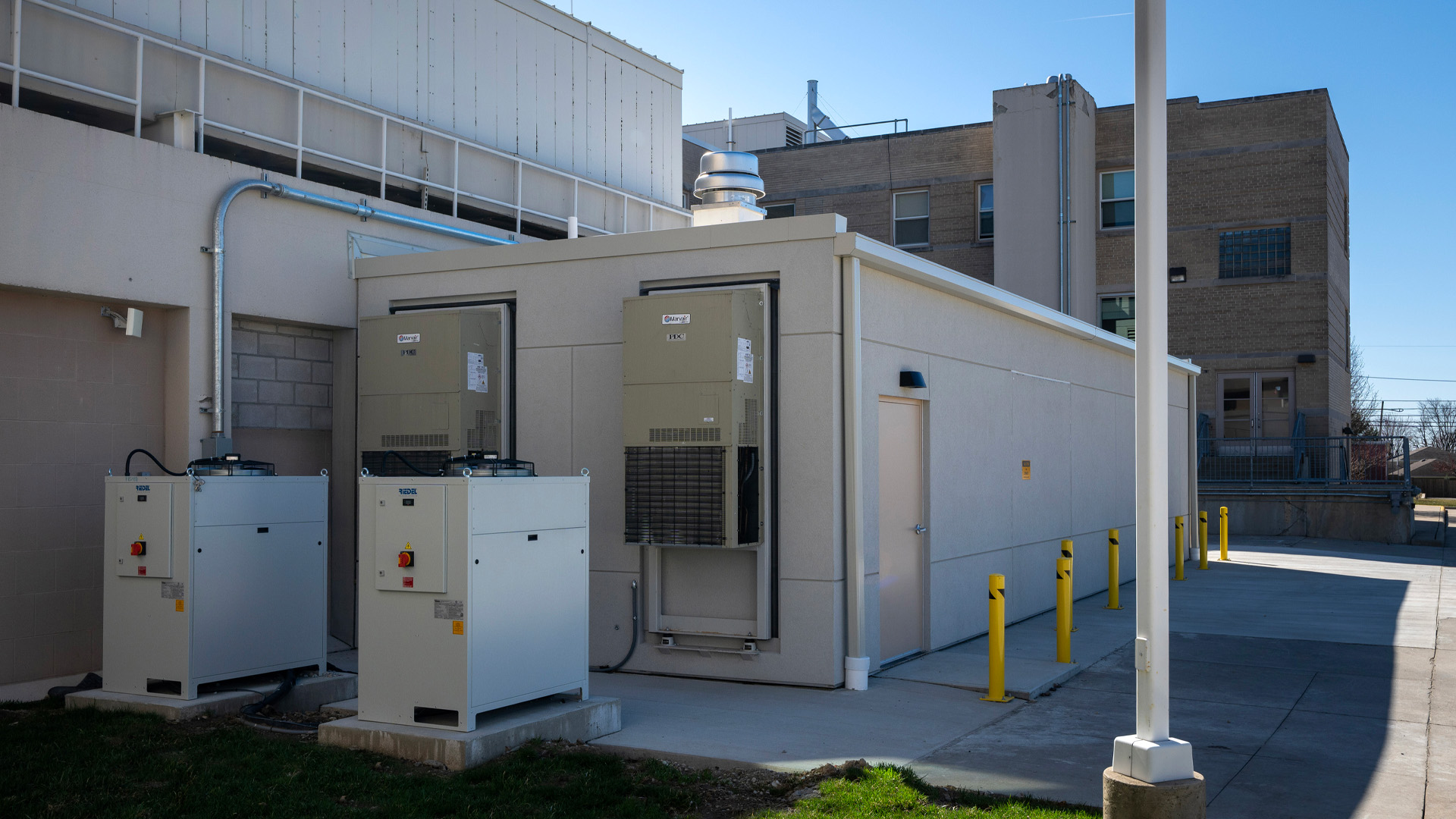 Outside view of the OhioHealth Hardin Hospital Prefabricated MRI Unit addition, featuring back of house engineering equipment.