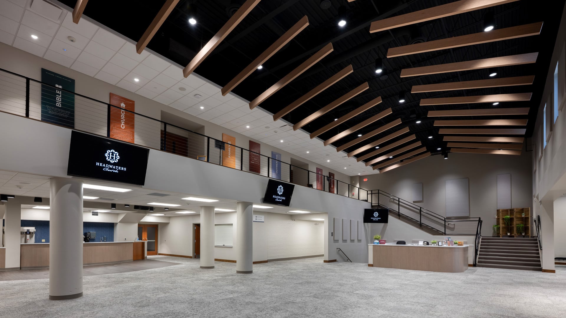 A wide open Lobby and gathering space at Headwaters Church in Fort Wayne Indiana with wood ceiling details.