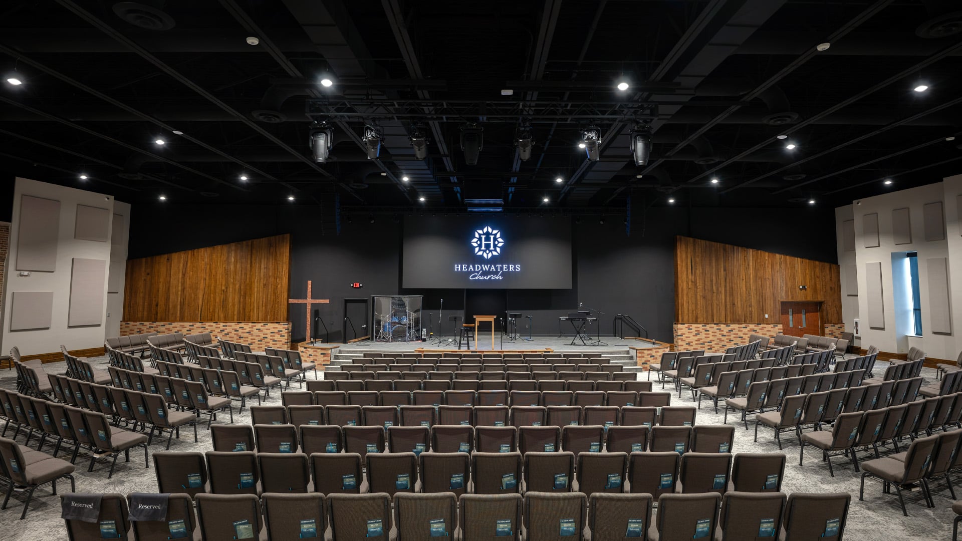 A wide sanctuary and auditorium with wood and brick accents at Headwaters Church in Fort Wayne Indiana.