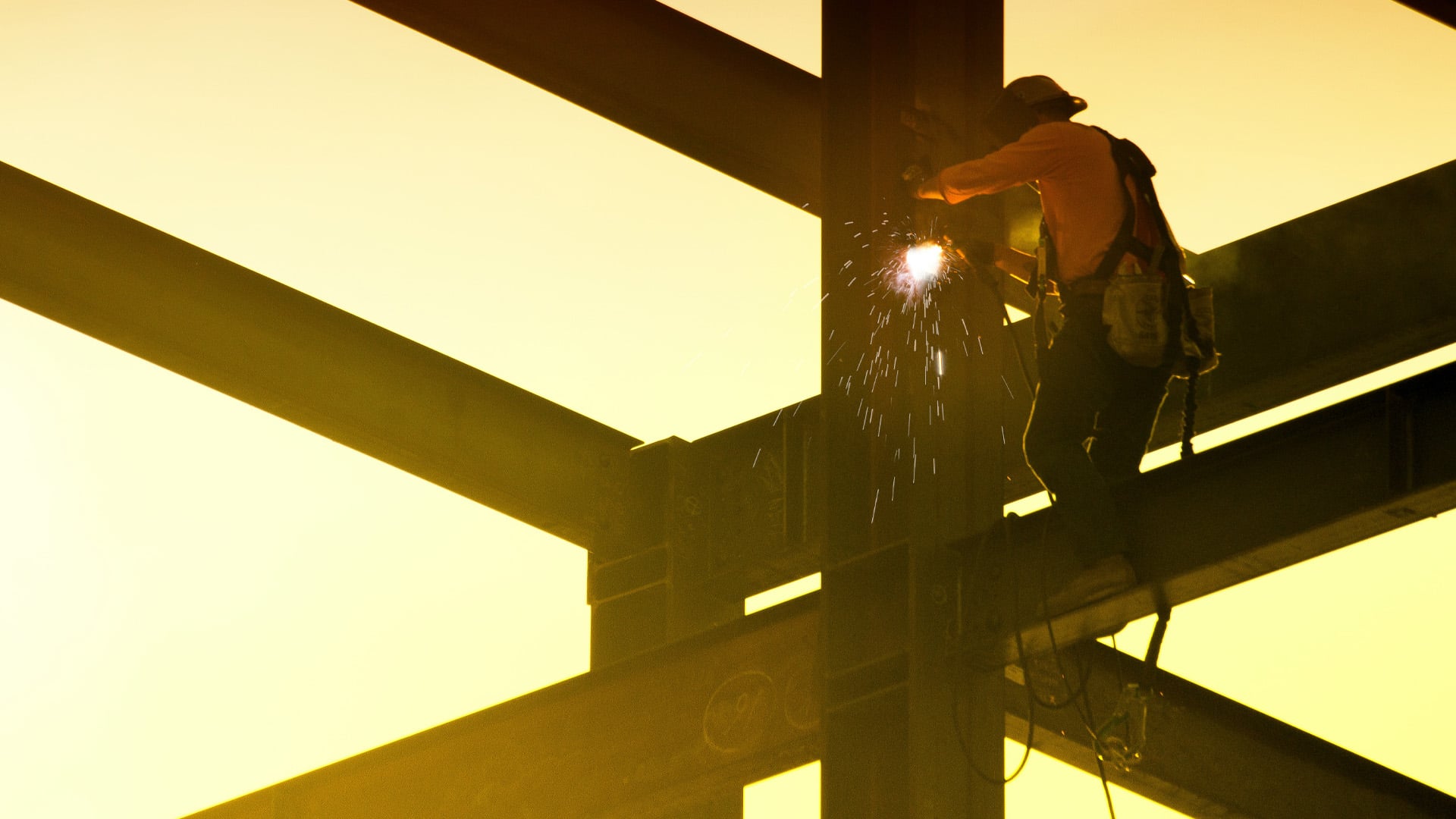 Man works on construction site at dusk.